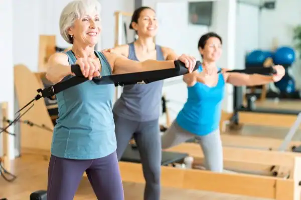 Toning Arms After 60: Empowering Womens Fitness Through Effective Weight Training 2 older woman doing weight training Northwood and resistance in the gym to tone upper arms