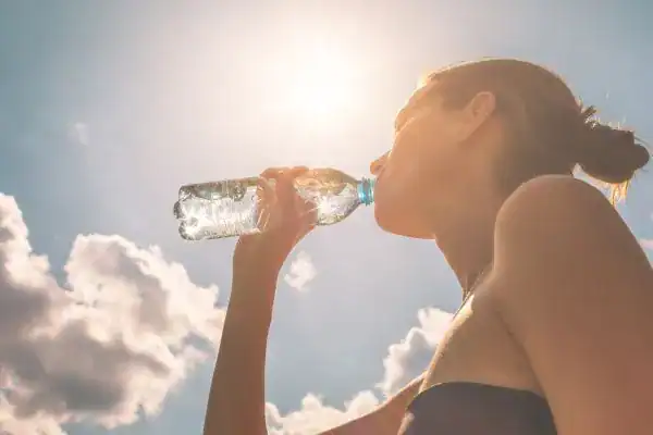 Hydration: The Secret Ingredient for a Toned Stomach and Enhanced Fitness 3 Image of woman drinking water to hydrate Northwood after run.