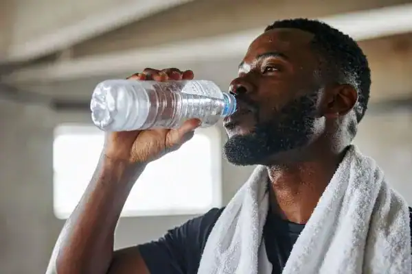 Hydration: The Secret Ingredient for a Toned Stomach and Enhanced Fitness 1 Image of man drinking water to improve hydration Northwood after work out.